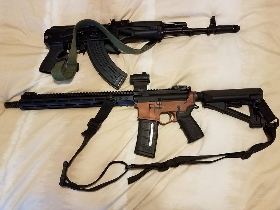 Two rifles, an AK-style and an AR-15 style, lying on a light-colored bedsheet.