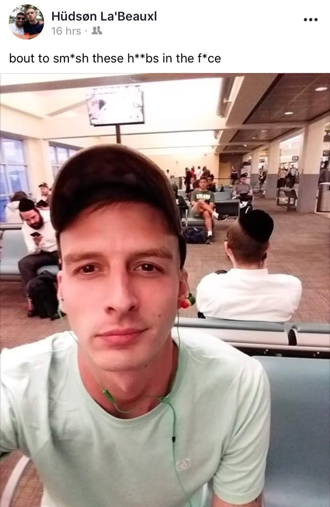 A screenshot of a Facebook post by Hüdsøn La'Beauxl showing a selfie of a young man in a green t-shirt and baseball cap at an airport. The caption contains a violent antisemitic threat. In the background, Jewish men wearing kippahs are seated.