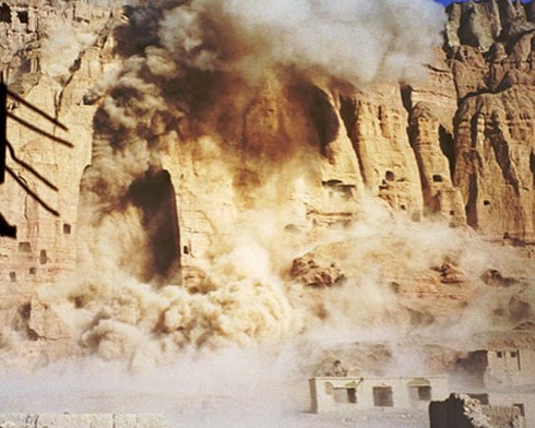 A photograph capturing the moment of a massive explosion destroying the Buddhas of Bamiyan in Afghanistan, with thick clouds of dust and debris billowing from the cliffside.