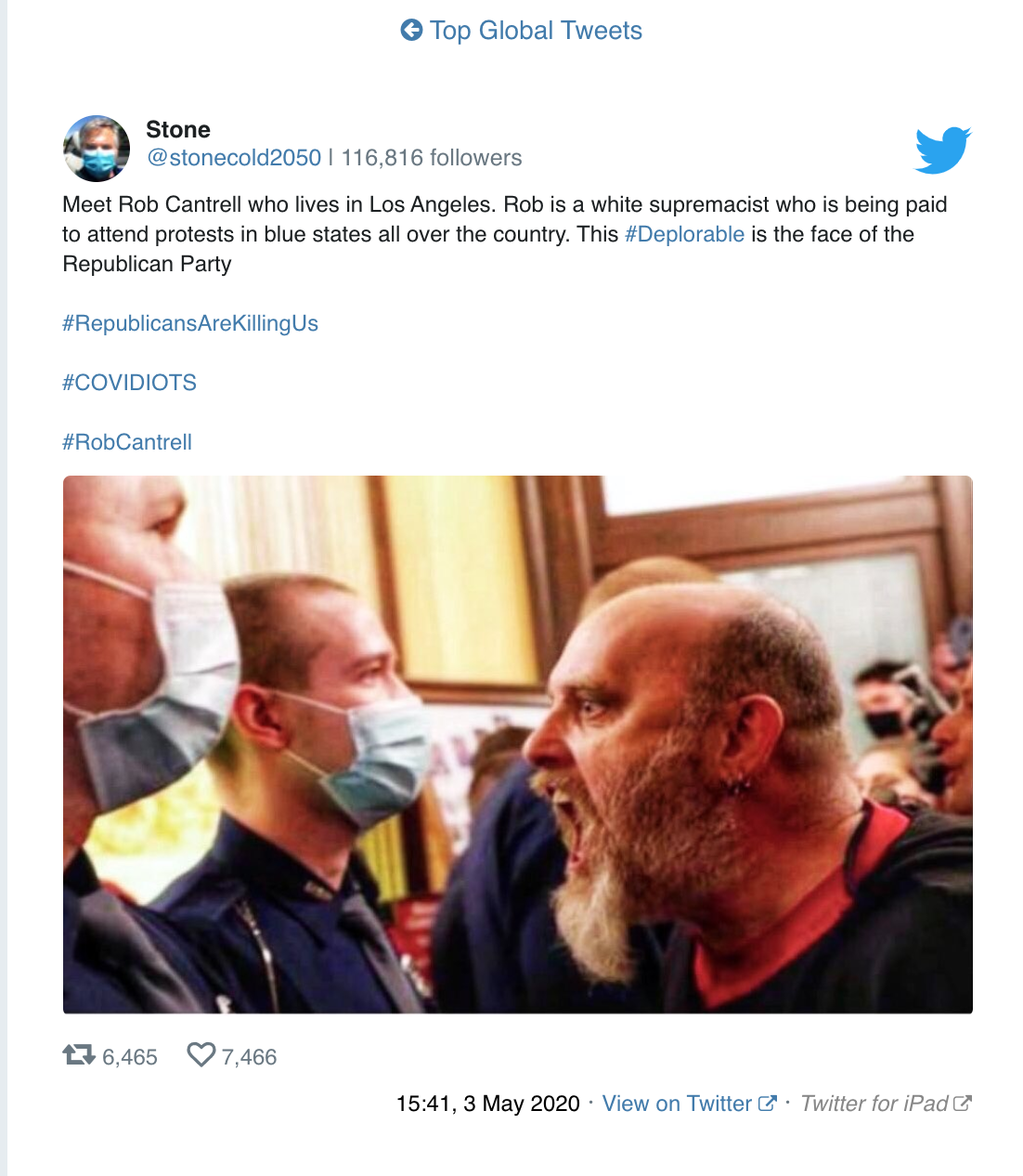 A screenshot of a tweet by @stonecold2050 featuring a photograph of a bald man with a full grey beard shouting at masked police officers. The tweet identifies the man as Rob Cantrell.