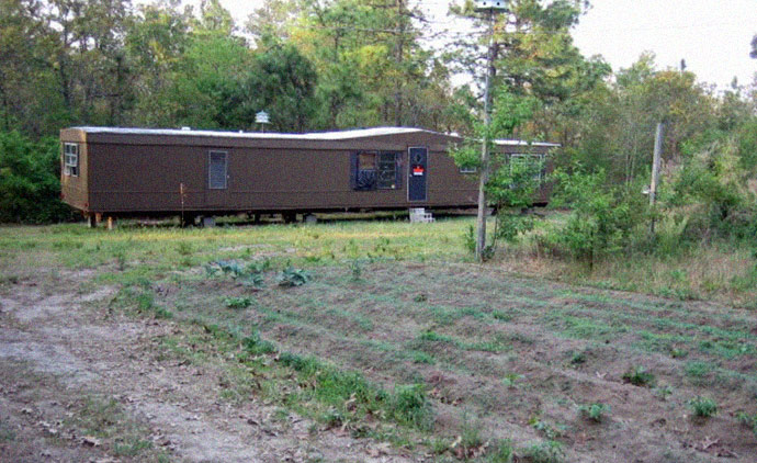 Single wide mobile home in Lexington County South Carolina headquarters of the Rural people's party showing North Korean flag flying and large cloth portraits of Kim Il Sung and Kim Jong Il obtained from North Korean government