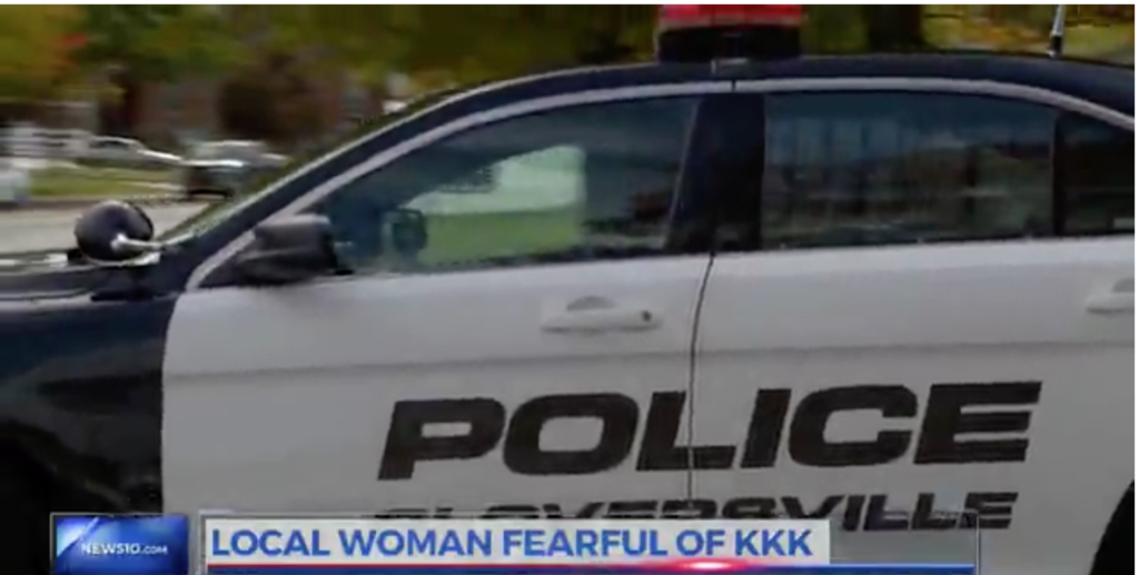 A screenshot from a News10 broadcast showing a Gloversville police car with a news ticker that reads 'LOCAL WOMAN FEARFUL OF KKK'.