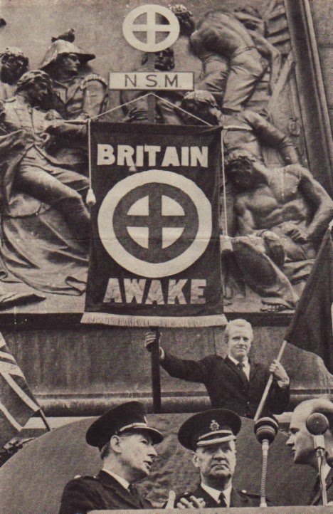 A 1962 photo of a far right wing British neo Nazi political party in Trafalgar Square. Note the symbol on flag which is the same as that drawn by Roof on South Carolina beach in March 2015