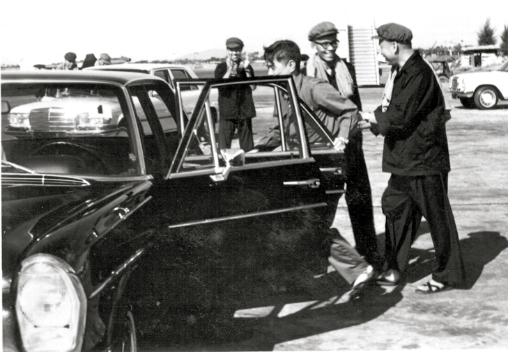 Pol Pot (right) walking into the car. The door was opened by his body guard and he was greeted by Son Sen (second from left), the Khmer Rouge Minister of Defense at Phnom Penh's Pochentong airport in the 1970's